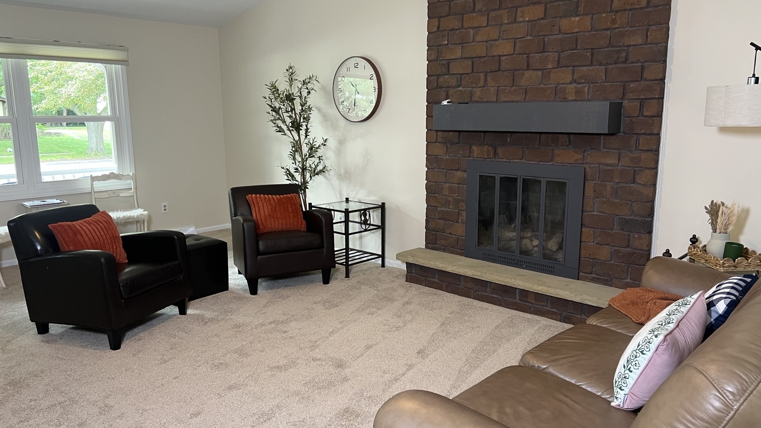Warm living room seating arranged around the brick fireplace